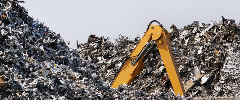 Scrap metal Recycling Insurance | Image of Metal scrapyard with buried excavator