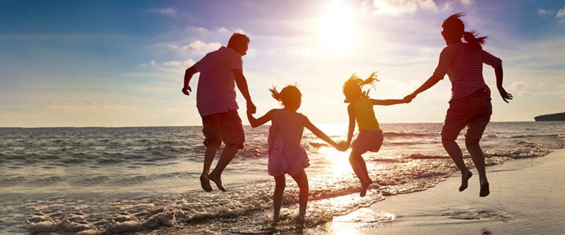 Personal Umbrella Insurance to protect your family - image of jumping family on the beach