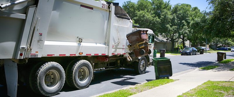 Waste hauler insurance | Garbage Truck in nice neighborhood